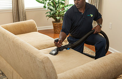 technician cleaning a sofa