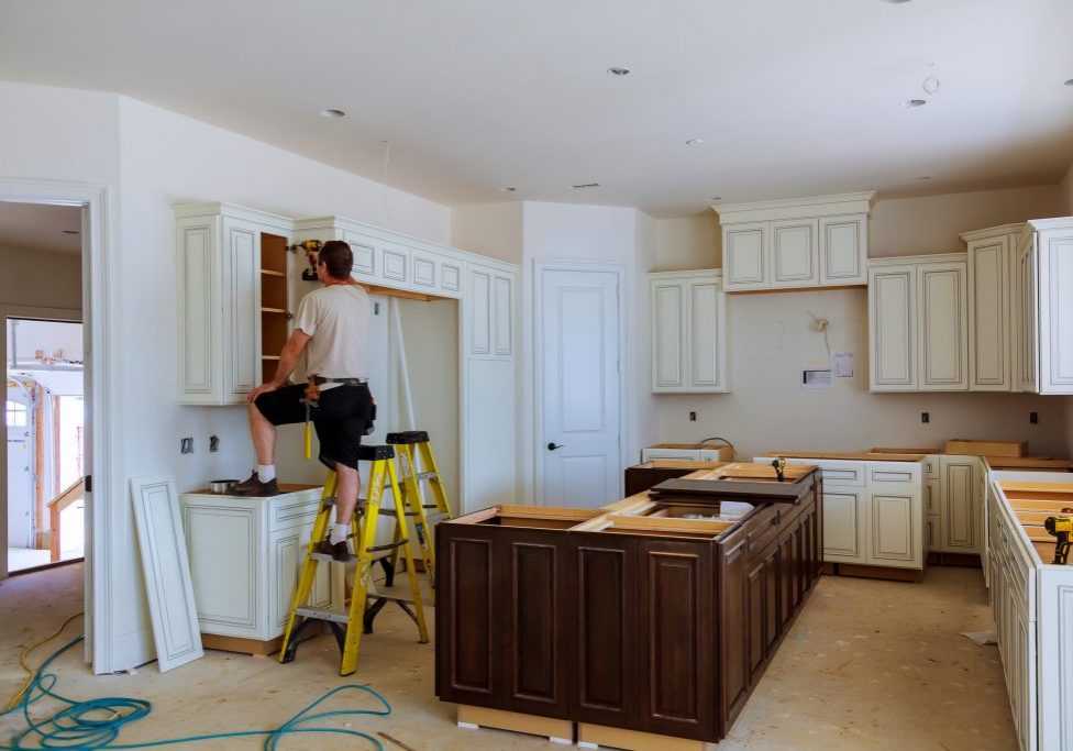 construction worker installing kitchen cabinets